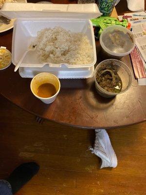 Tray of rice, cup of beans, meat in a container.