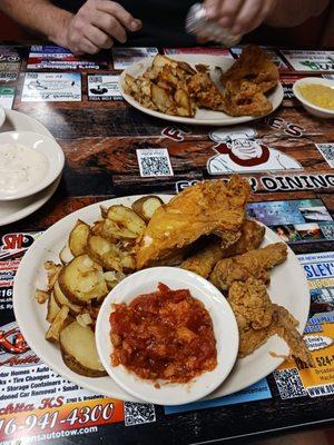 Yardbird, breaded tomatoes, fried potato with onion. Other plate has creamed corn