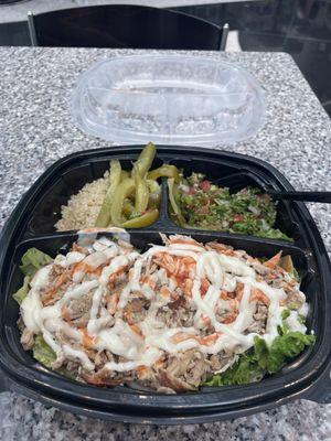 Chicken shawarma plate on lettuce with quinoa, tabbouleh and pickles