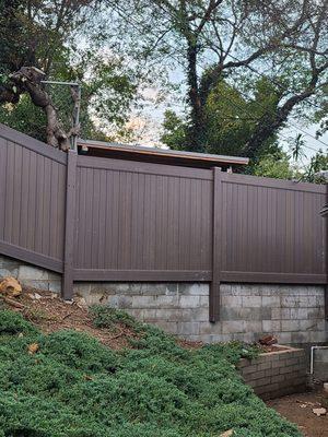 Vinyl fence attached to cement block wall