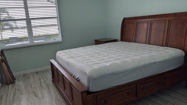 Beautiful bedroom with king sized storage bed. Delivery staff put it together and centered it on the wall.