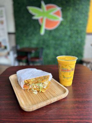 A grilled chicken patacon with a mango and orange juice smoothie