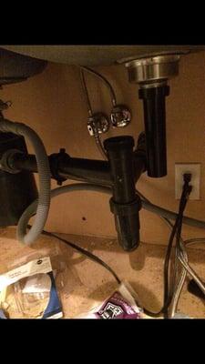 Unfinished plumbing under sink where disposal literally fell off.