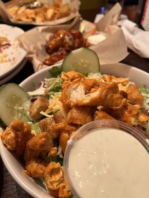 Buffalo chicken salad. In the background hot teriyaki wings