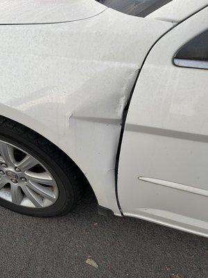 The giant dent this joke of a mechanic's shop left on my car