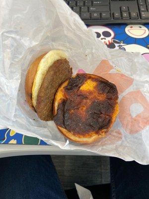 Sausage Egg And Cheese sandwich. The black stuff is the cheese. What kind of human cooks this and thinks it's okay to send it out.