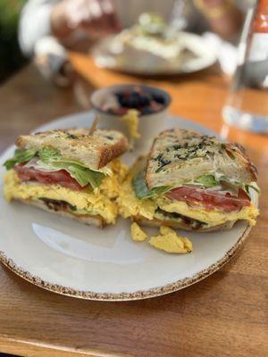 Grilled breakfast sandwich - Eggs over medium, uncured bacon, avocado, red onion, tomato, lettuce, mayo, cheddar cheese on sourdough.