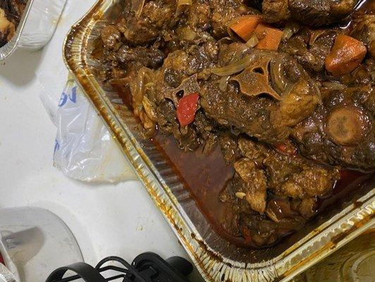 A catered pan of oxtails full of grease