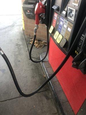 Dirty gas pump and grease and gas on the ground and they want clean this but people spend money here