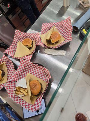 Some of the prepared burgers and fries on the eat-in platters