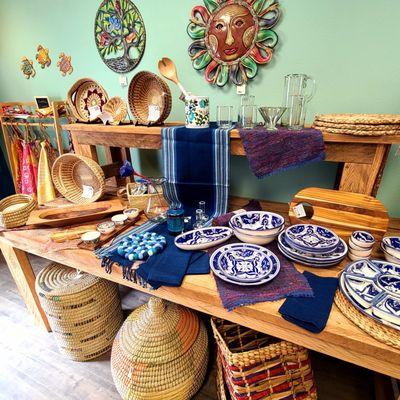 Wood tabled filled with blue ceramic dishes from Tunisia and baskets from around the world.