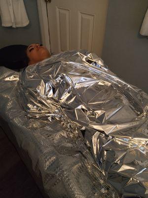 Manual lymphatic drainage with mylar wrapping and infrared sauna bed to rid of excess water weight and tighten skin.