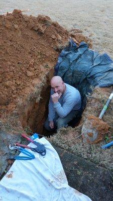 Jeff in the hole on a leak repair