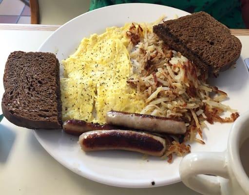 Scrambled eggs, sausage, hash browns, and rye toast.