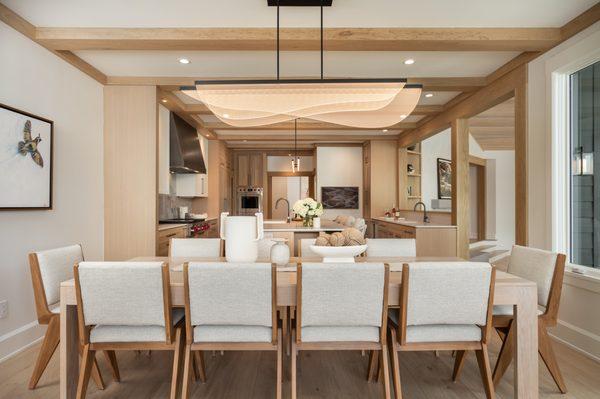 Dining Room with LED lighting, custom dining table, and outdoor rated upholstered chairs, with white oak floors and beams.