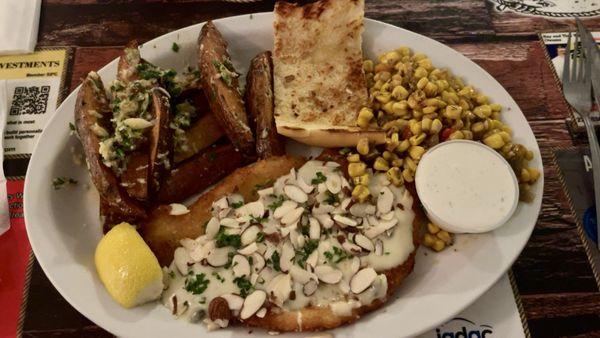 Calamari steak with garlic butter jojos, fire roasted corn, and garlic bread.