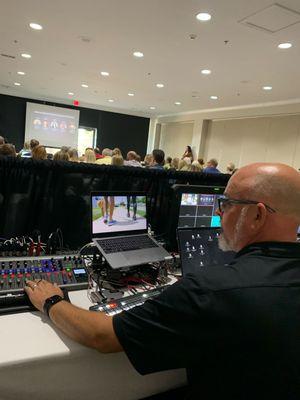 Live video production operator running sound and video switching