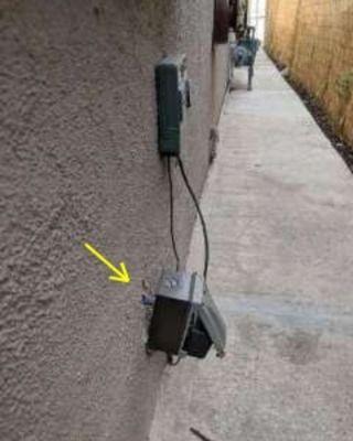 Exterior electrical outlet not properly installed. Falling off. Posing a possible safety hazard.