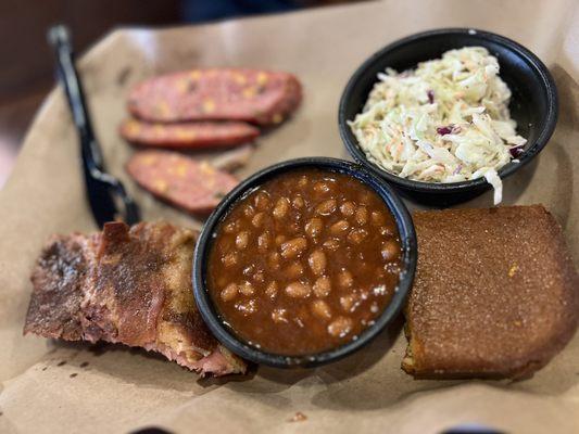 Two meat platter with baked beans, coleslaw, and cornbread