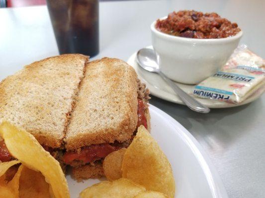 The day's special of a meatloaf sandwich and chips plus a bowl of chili and Pepsi.