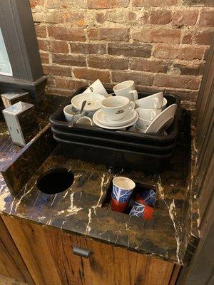 Dirty dishes, overflowing garbage, and an empty napkin dispenser