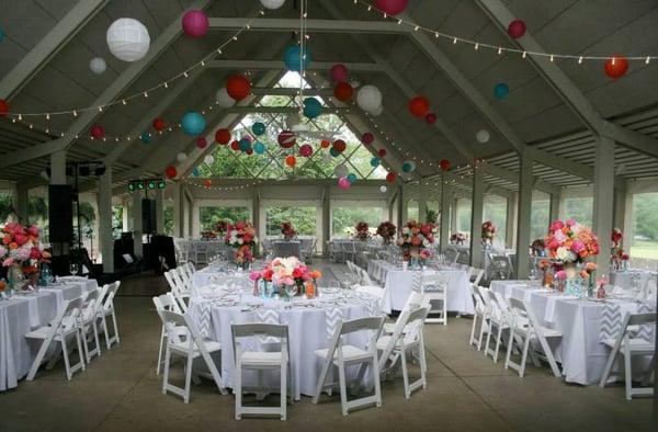 White folding garden chairs, chevron napkins and table runners and colorful lanterns