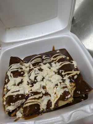 Chicken Mole Enchiladas topped with Mexican creme and fresh cheese