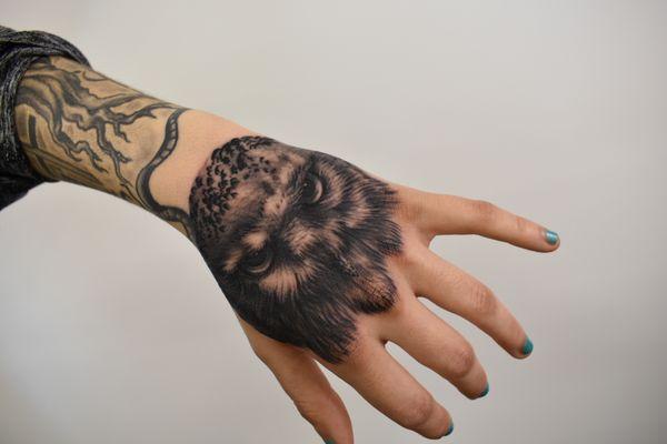 Realistic blackwork owl hand tattoo