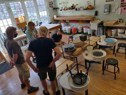 Pottery Class scene of students watch instructors demonstration