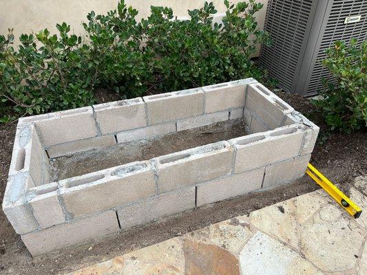 Back wall shorter than front wall and above the patio/ground level by about 2 inches.