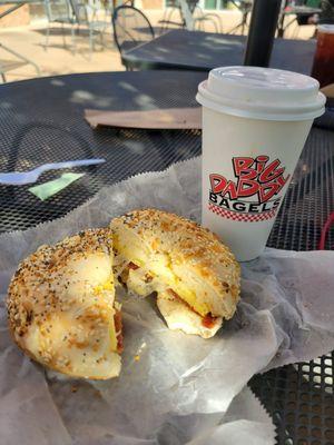 Delicious egg, cheese and bacon bagel with a cappuccino enjoyed on their patio