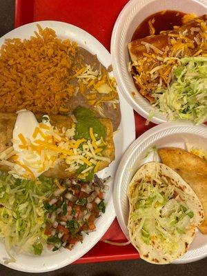 One platter has a chimichanga(ground beef) beans and rice. Two chicken enchiladas,a puffy  taco