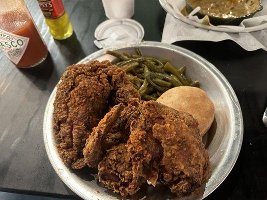 Half chicken meal with green beans and a biscuit