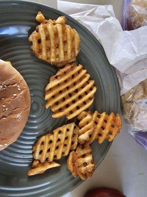 A plate showing the paltry 5 waffle fries given with an order.