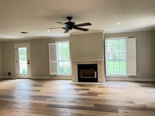 New living room with newly built fireplace, floors, door and lighting.