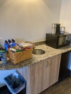 Kitchenette with coffee maker and mini fridge.