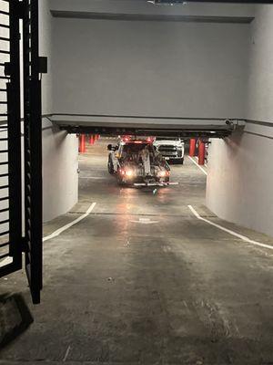 Rebello's towing truck entering through an apartment parking complex's exit, and blocking off the exit to prevent anyone from leaving.