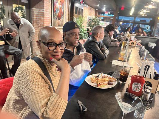 Family enjoying food, conversation and tv at the bar as we waited for others to arrive for our meet up.