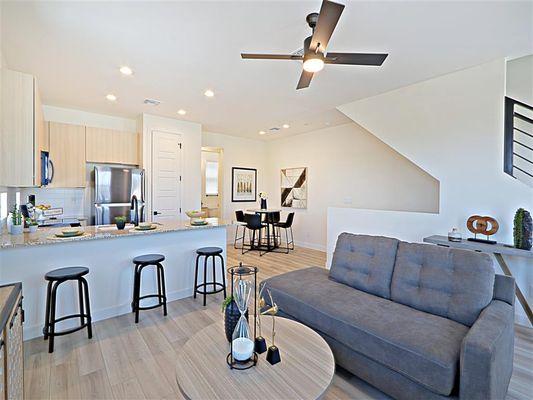 A living room with a couch and a kitchen in the background