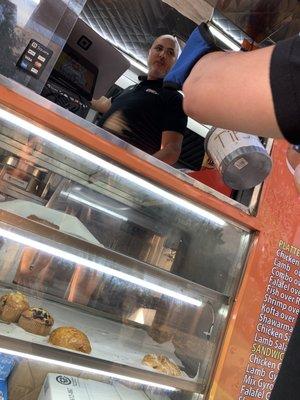 Friendly food truck owner and pastries in cart window