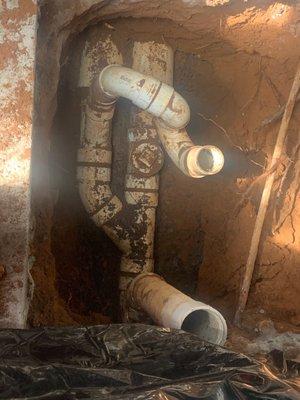 Before: The outdoor basement entrance sewer and storm water outflow pipes. (Upper open pipe is floor drain; lower open pipe is clean out.)