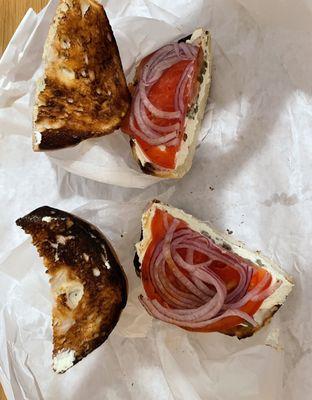 Burnt, inedible bagel with plain cream cheese, tomato, onions, capers