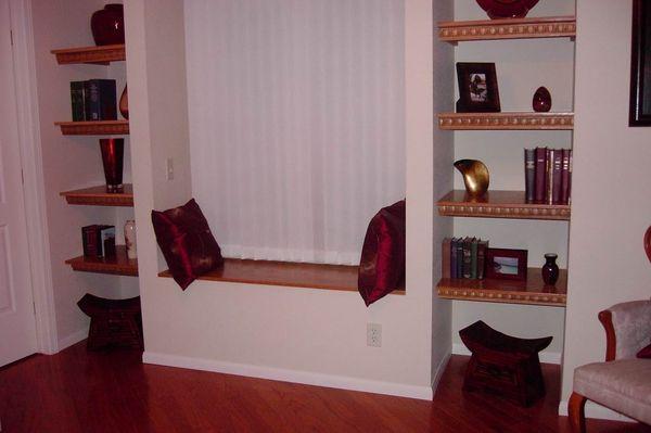 Cozy den with custom wood shelving, window seat and hardwood floors.