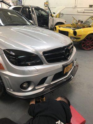 Custom splitter being installed on this Mercedes