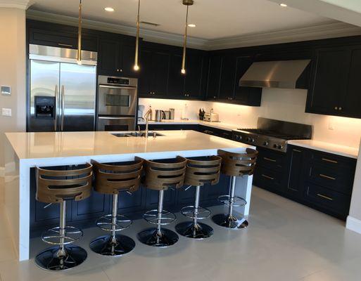 Ultra modern kitchen - dark blue cabinets with Gold hardware and Gold pendant lights