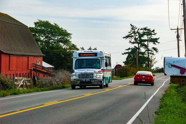 Island Transit driving along Fort Casey Road in Coupeville, WA.