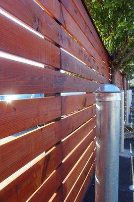 New work for @Super8 San Bruno! Horizontal redwood fence with parking bollards.