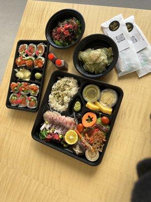 Yellowtail bento and spicy tuna roll, seaweed salad, and cucumber salad.