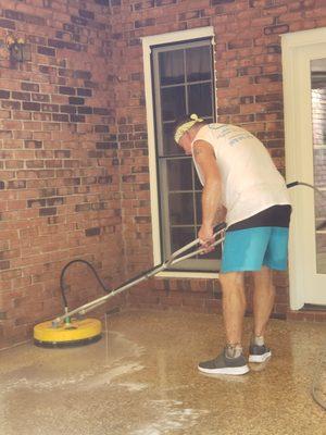 Jim at work pressure washing a floor, demonstrating our team's dedication to thorough and effective cleaning.