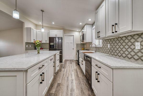 Long spacious island with plenty of working area. Beautiful glass tile mosaic and white shaker cabinets. All new lighting layout.